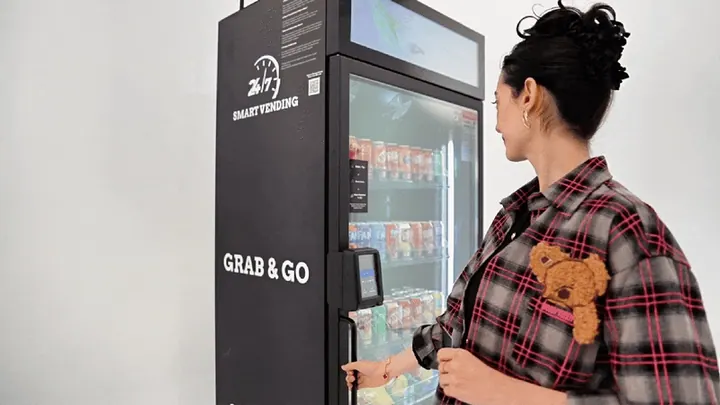 A customer closes a smart cooler after choosing products